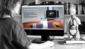 A woman looking into the screen with e-learning programm for electrosurgery.