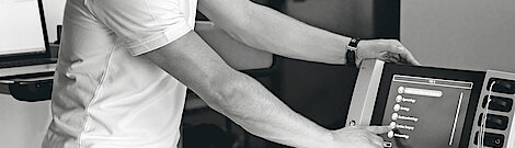 A biomedical engineers taps on the VIO3 touch display to select an option.